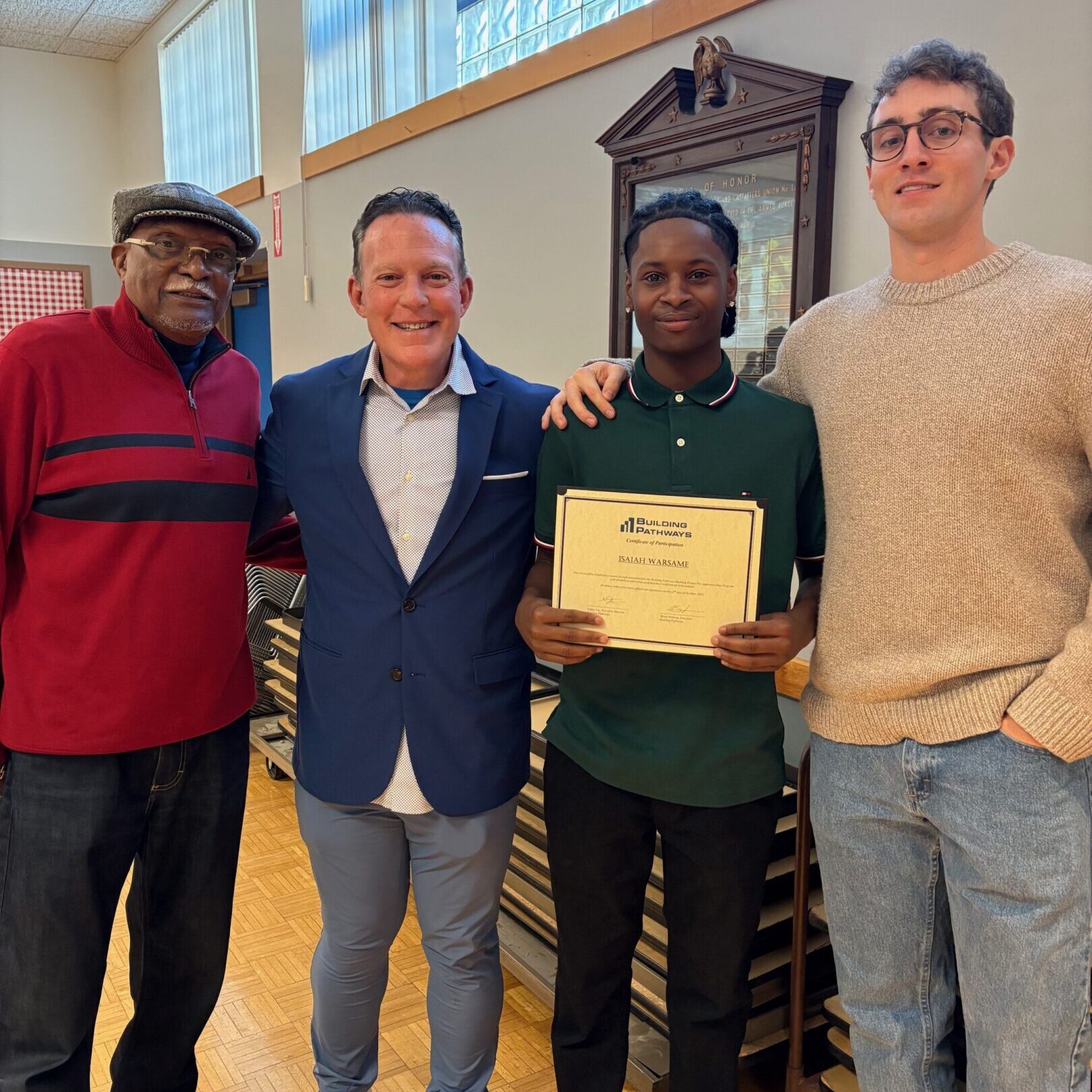 Four people posing with certificate